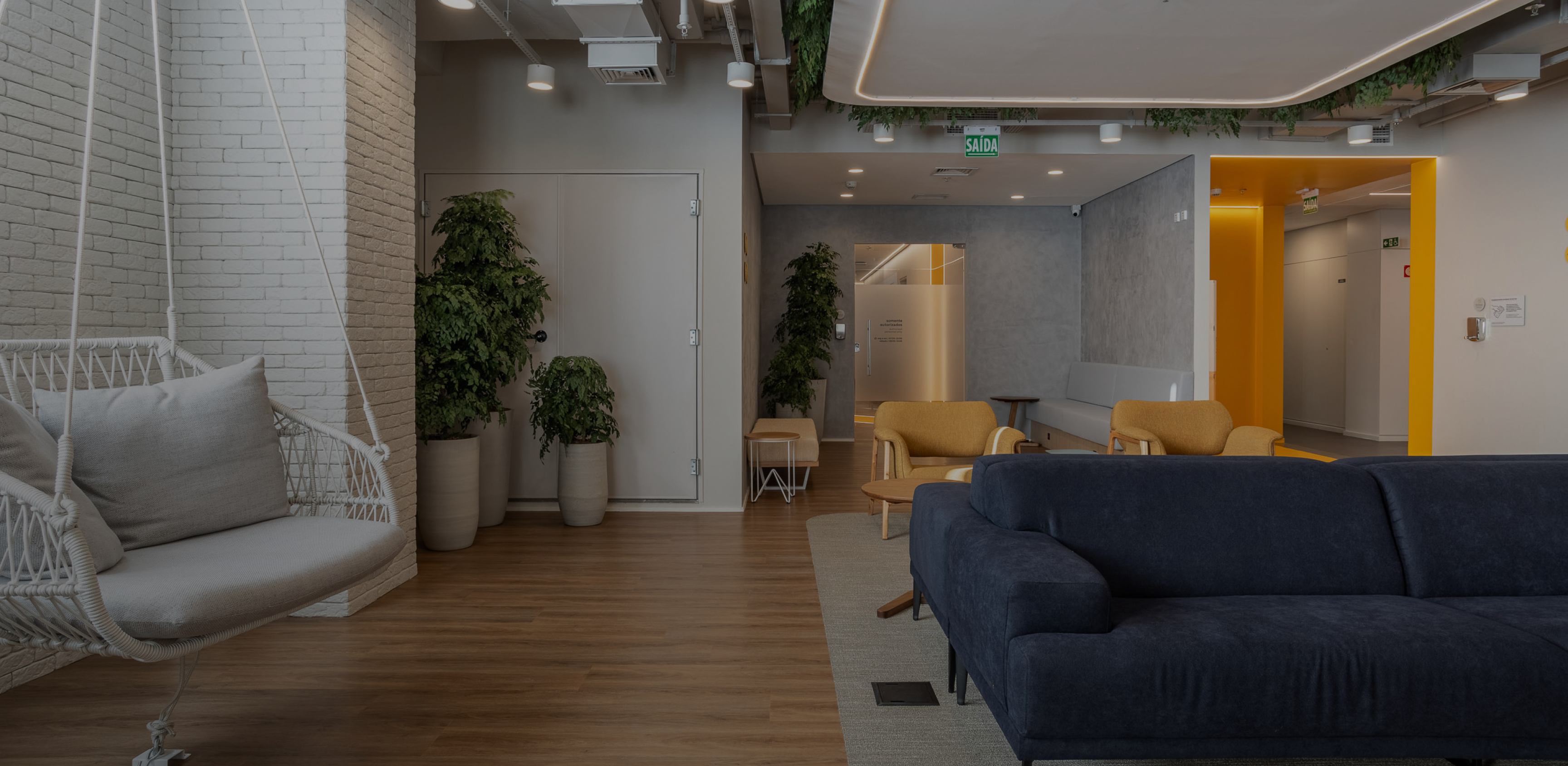 Recepção do prédio onde fica o consultório no Tatuapé, com plantas, poltronas e balanço de fibra